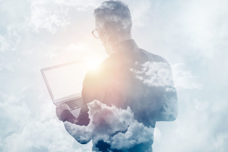 White image with a black shadow of the back of a male figure holding a laptop with clouds around him