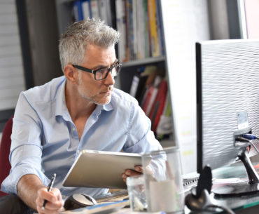 business man sitting in front of desk top computer