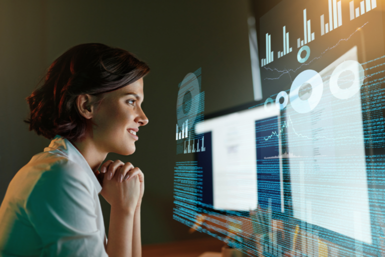 Maturing Industry Ecosystem Strategy and Investments for Enhanced Decision Velocity Person smiling, while looking at two computer monitors with charts