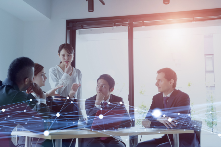 Evolving Digital Marketing Strategies in the Era of AI Everywhere Group of professionals in a meeting room with a data overlay.