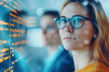 woman wearing glasses, digital screens reflecting off her lenses
