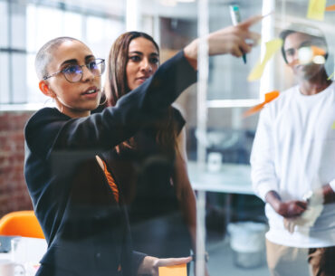 Marketing leader presenting strategy ideas to a diverse team during a planning session in a modern office.