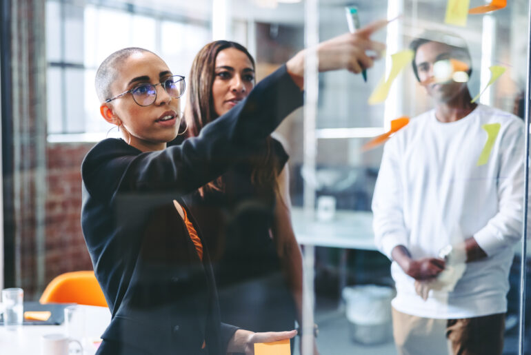 Marketing leader presenting strategy ideas to a diverse team during a planning session in a modern office.