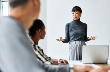 Business leader presenting digital transformation strategies to colleagues in a modern office setting.