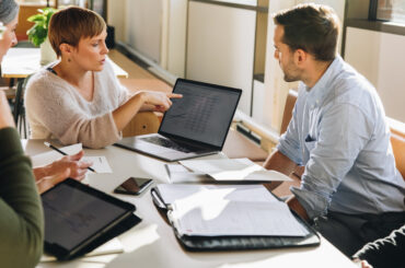 Business team reviewing analytics and discussing governance implications during a strategic meeting.