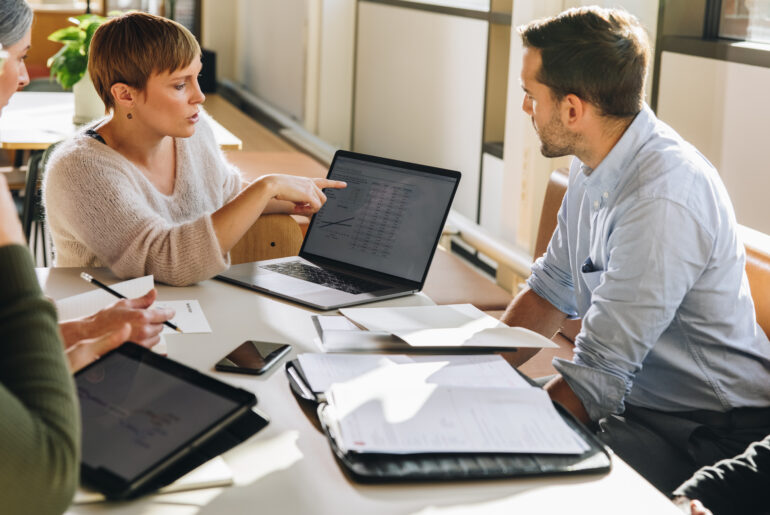 Business team reviewing analytics and discussing governance implications during a strategic meeting.